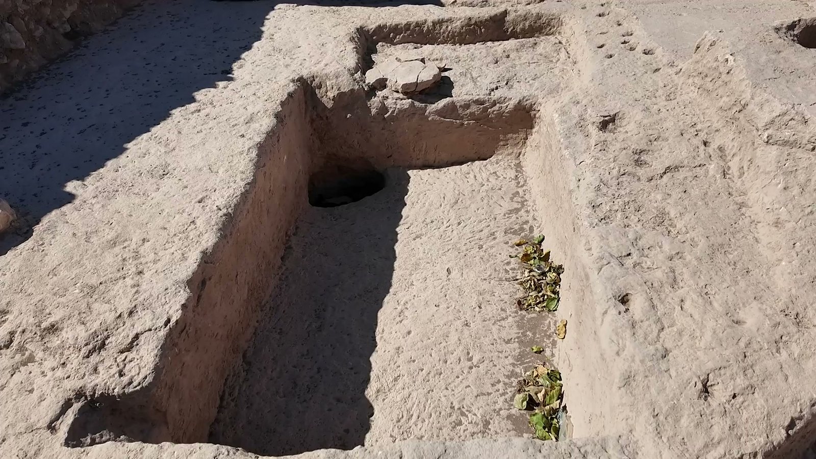 A rectangular pit cut into the bedrock floor inside a house at Sayburç