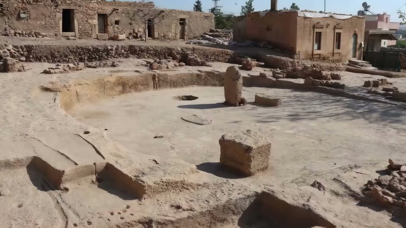 A circular communal building at Sayburç exposed by excavation, a standing stone at its centre